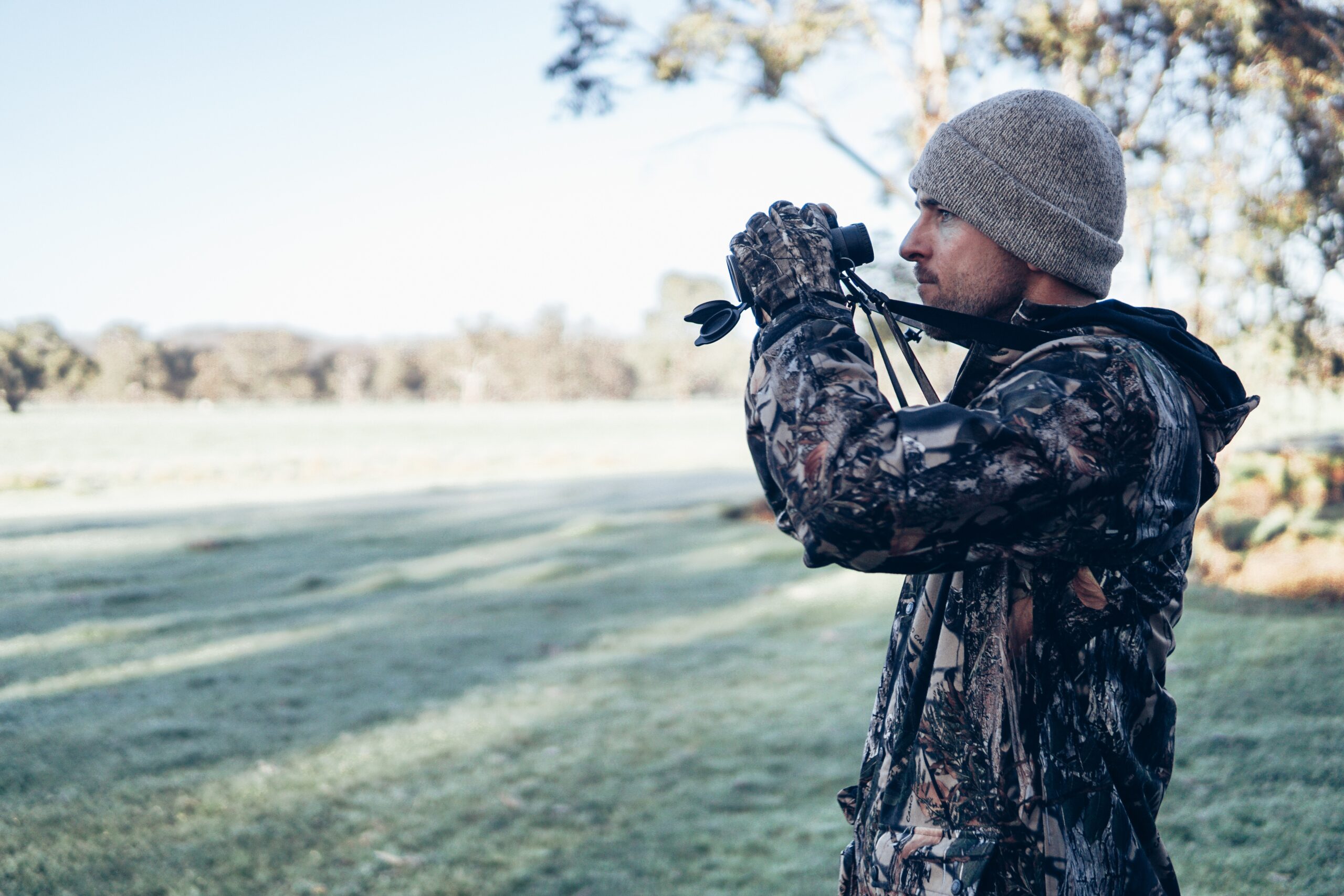 man in camo with binoculars - landowners can provide hunting leases on their property